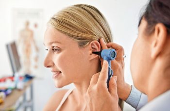 перевірка вух на прийомі у лікаря, отит, біль у вусі