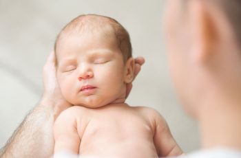 зображення новонародженої дитини в татових руках